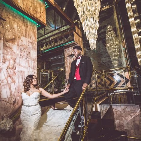 Bride and groom descending staircase.